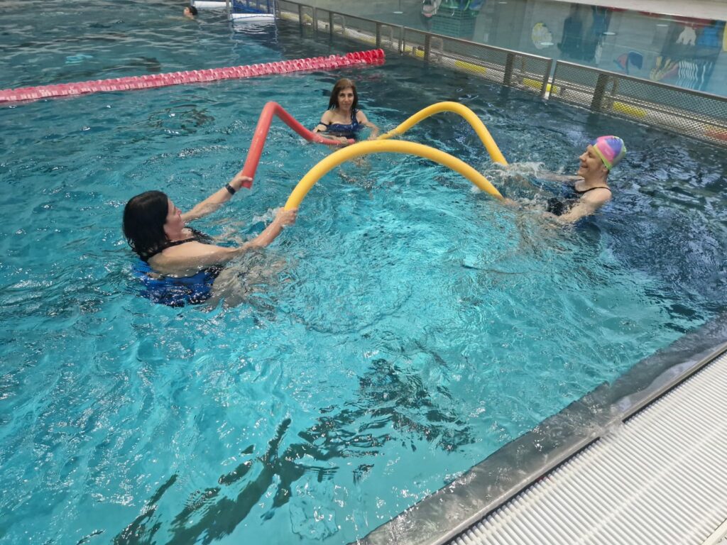 Kursteilnehmerinnen bei der Wassergymnastik mit Poolnudeln