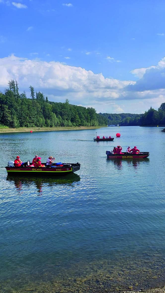 DLRG-Boote sichern die Freiwasserstrecke auf der sonnigen Aggertalsperre.